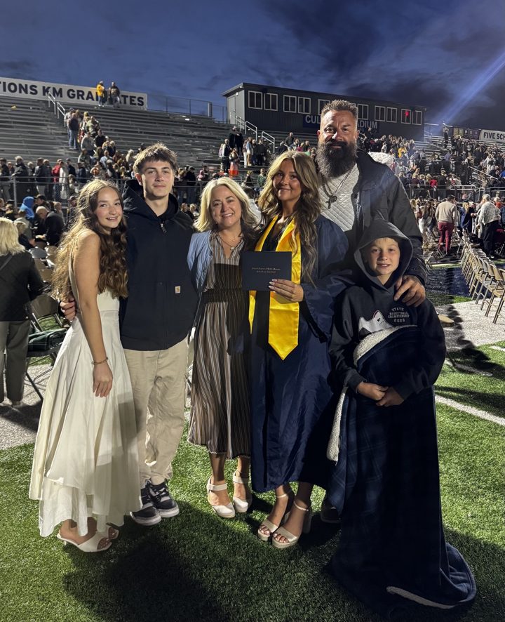 A group celebrating a graduation on a field