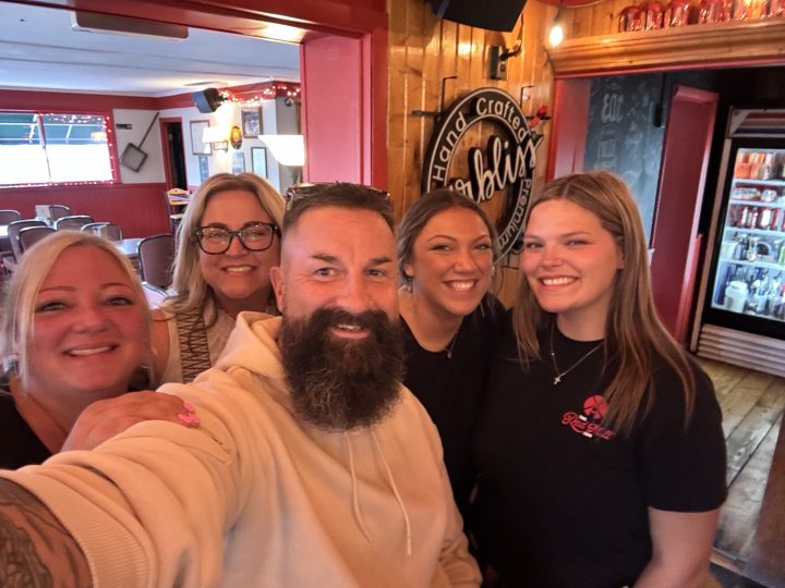 A group smiling together for an indoor selfie
