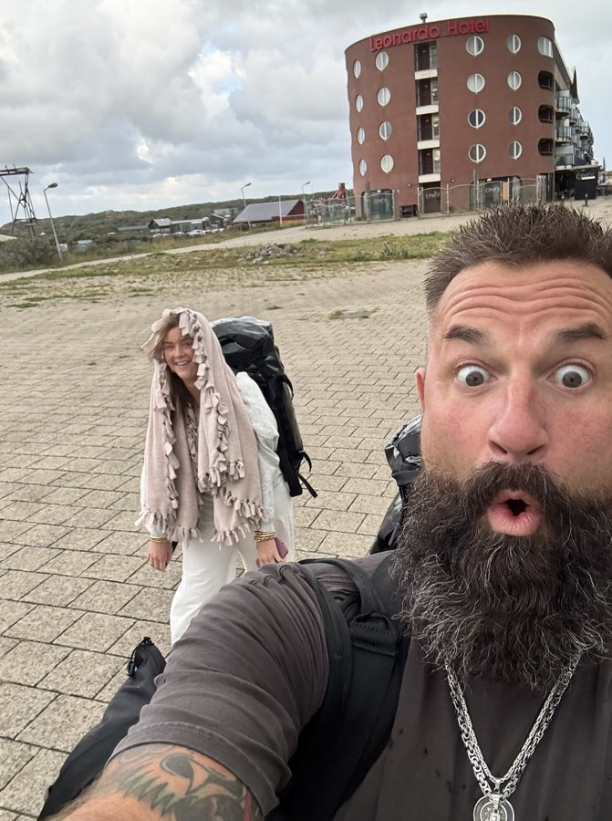 A playful travel selfie on a waterfront walkway