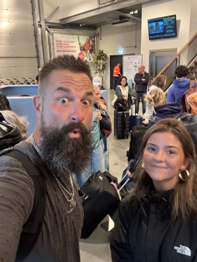 Two travelers smiling for a selfie in a terminal