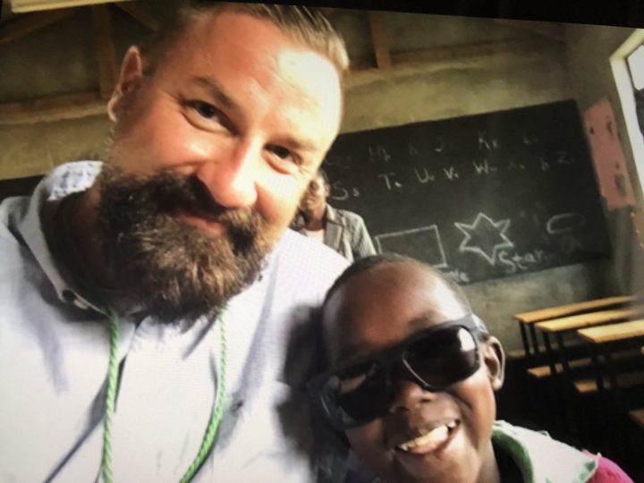 Two people smiling for a selfie in a classroom